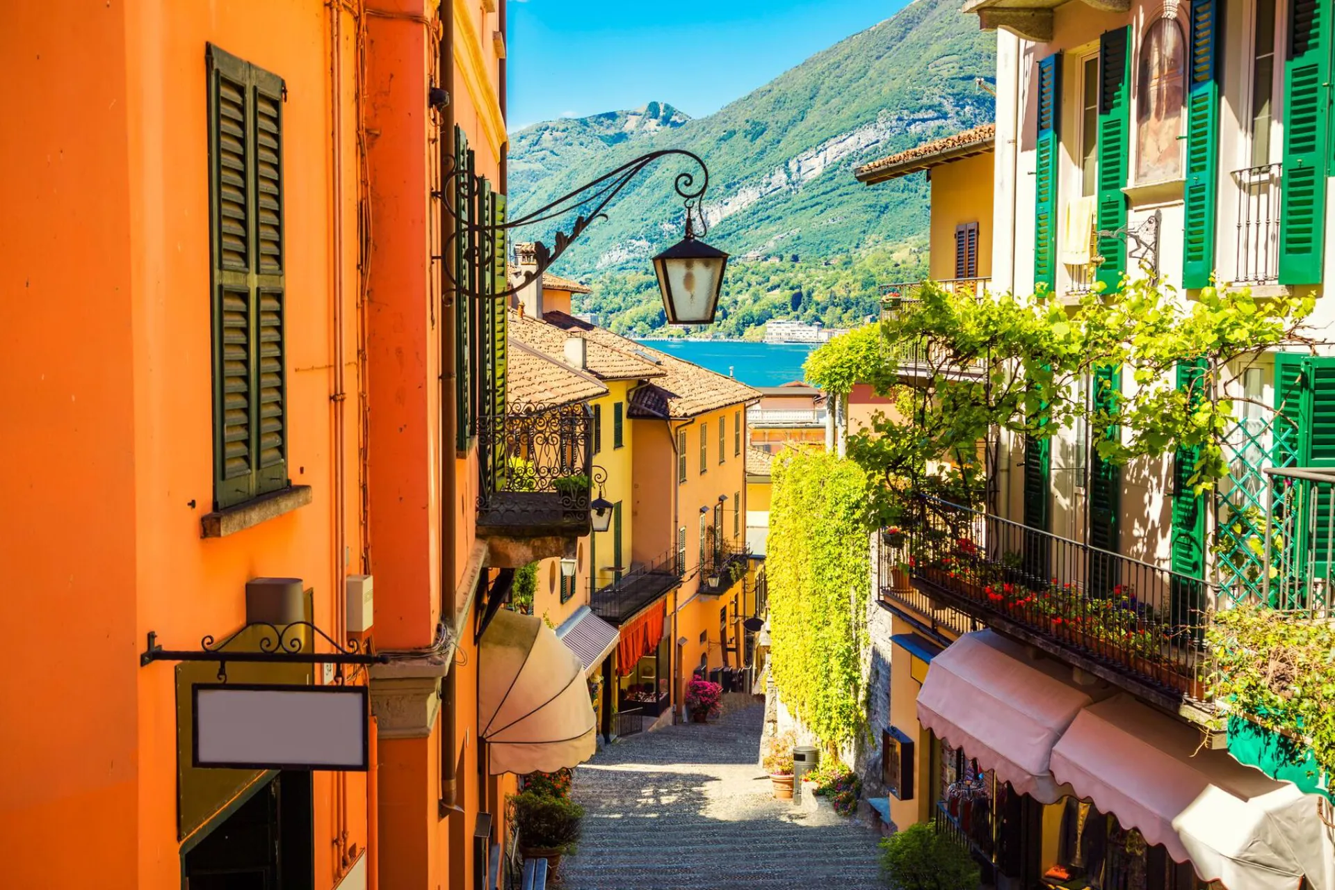Colourful buildings with a steep alleyway going down to a lake in Bellagio, Italy